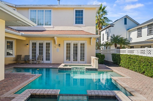 7550 Gathering Dr, Reunion, FL 34747 - rear view of house featuring french doors, a pool with connected hot tub, stucco siding, and a patio area