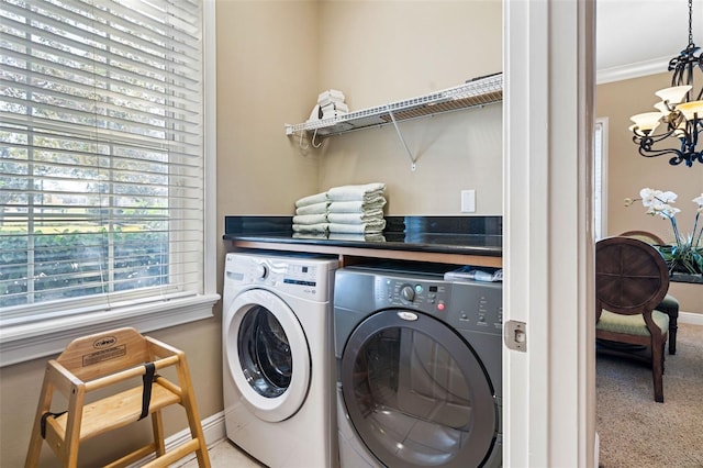 7550 Gathering Dr, Reunion, FL 34747 - laundry area featuring washing machine and clothes dryer, a chandelier, carpet floors, baseboards, and crown molding