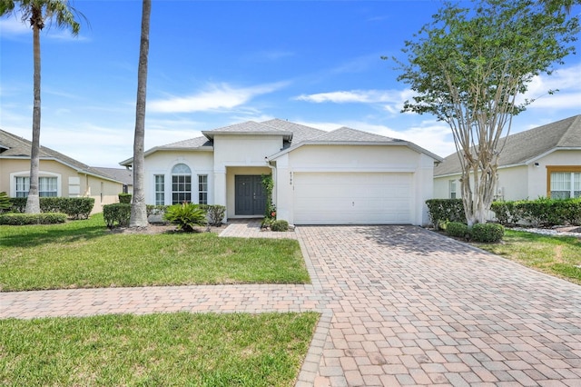 4796 Cumbrian Lakes Dr, Kissimmee, FL 34746 - view of front of house with stucco siding, decorative driveway, an attached garage, and a front lawn