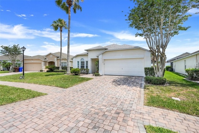 4796 Cumbrian Lakes Dr, Kissimmee, FL 34746 - ranch-style home with decorative driveway, an attached garage, a front lawn, and stucco siding