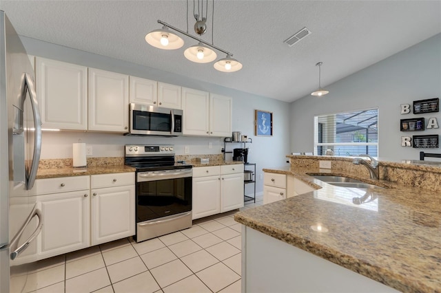 4796 Cumbrian Lakes Dr, Kissimmee, FL 34746 - kitchen featuring stainless steel appliances, a sink, vaulted ceiling, white cabinetry, and decorative light fixtures