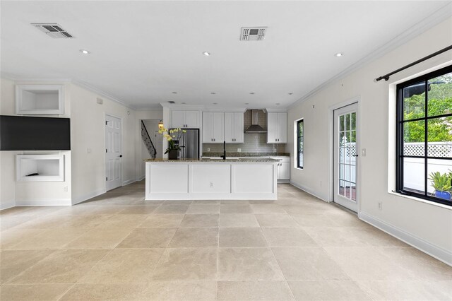 1047 Banks Rose St, Kissimmee, FL 34747 - kitchen featuring wall chimney range hood, freestanding refrigerator, crown molding, white cabinets, and tasteful backsplash
