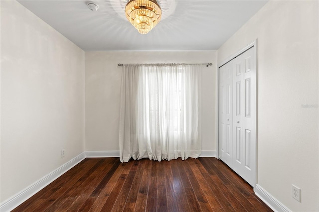 1047 Banks Rose St, Kissimmee, FL 34747 - unfurnished bedroom with dark wood-type flooring, baseboards, a closet, and a chandelier