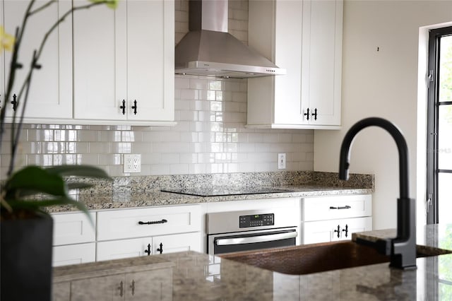 1047 Banks Rose St, Kissimmee, FL 34747 - kitchen featuring wall chimney range hood, stainless steel oven, black electric stovetop, and decorative backsplash