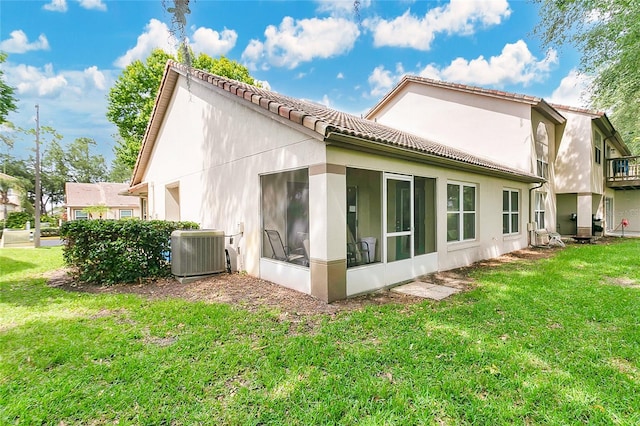 2473 Saint Augustine Blvd, Haines City, FL 33844 - rear view of house with cooling unit, a sunroom, stucco siding, a lawn, and a tiled roof