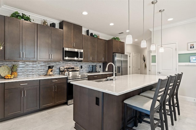3428 Sagebrush St, Saint Cloud, FL 34773 - kitchen featuring appliances with stainless steel finishes, a sink, ornamental molding, decorative backsplash, and a kitchen bar