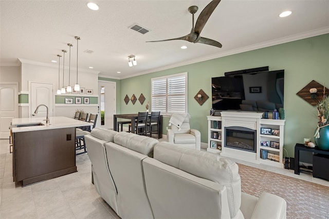 3428 Sagebrush St, Saint Cloud, FL 34773 - living room featuring ceiling fan, recessed lighting, light tile patterned floors, ornamental molding, and a glass covered fireplace