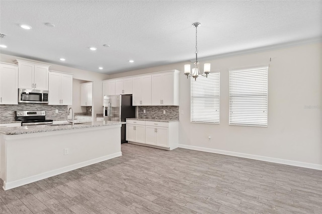 3138 Dark Sky Dr, Saint Cloud, FL 34773 - kitchen featuring appliances with stainless steel finishes, decorative backsplash, light wood finished floors, a chandelier, and a sink