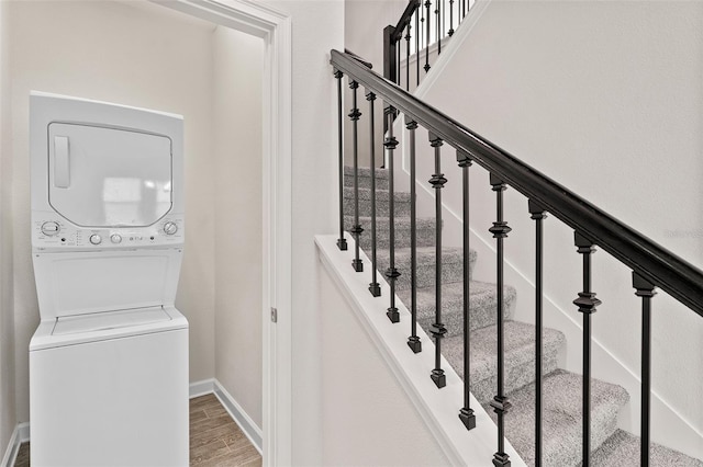 3138 Dark Sky Dr, Saint Cloud, FL 34773 - stairway featuring stacked washing machine and dryer, baseboards, and wood finished floors