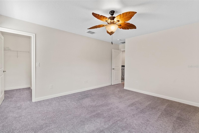 3138 Dark Sky Dr, Saint Cloud, FL 34773 - unfurnished bedroom with a walk in closet, carpet, baseboards, and a ceiling fan