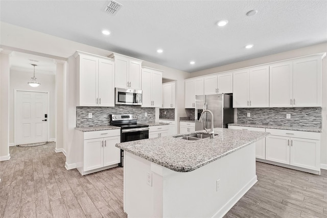 3138 Dark Sky Dr, Saint Cloud, FL 34773 - kitchen featuring stainless steel appliances, a sink, tasteful backsplash, light wood finished floors, and ornamental molding