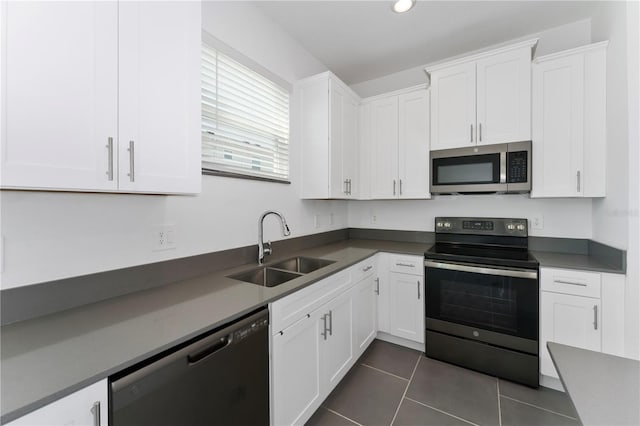 7728 Stone Creek Trl, Kissimmee, FL 34747 - kitchen with stainless steel appliances, a sink, white cabinetry, and dark tile patterned flooring