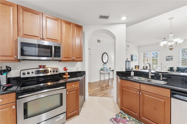 7509 Mourning Dove Cir Unit 303, Reunion, FL 34747 - kitchen featuring appliances with stainless steel finishes, a sink, dark countertops, a chandelier, and light tile patterned floors