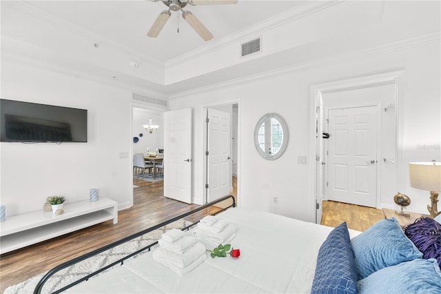 7509 Mourning Dove Cir Unit 303, Reunion, FL 34747 - bedroom featuring wood finished floors, crown molding, a ceiling fan, and a tray ceiling