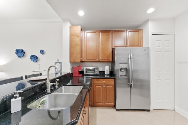 7509 Mourning Dove Cir Unit 303, Reunion, FL 34747 - kitchen with appliances with stainless steel finishes, a sink, dark stone counters, ornamental molding, and light tile patterned floors