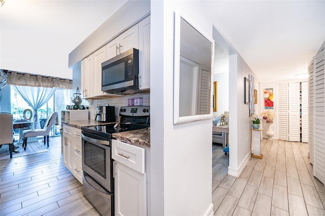 4403 S Semoran Blvd Unit 2, Orlando, FL 32822 - kitchen featuring stainless steel appliances, white cabinets, and light wood-style floors