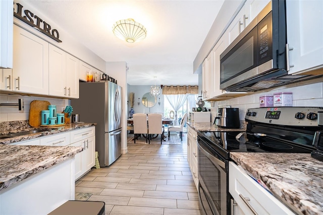 4403 S Semoran Blvd Unit 2, Orlando, FL 32822 - kitchen with appliances with stainless steel finishes, a sink, decorative backsplash, white cabinetry, and light stone counters