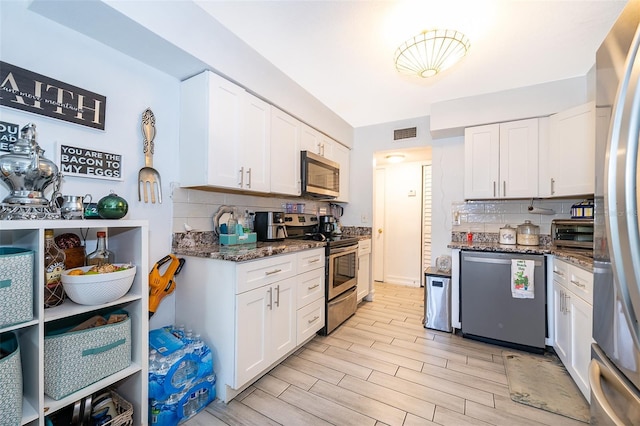 4403 S Semoran Blvd Unit 2, Orlando, FL 32822 - kitchen with stainless steel appliances, tasteful backsplash, and white cabinetry