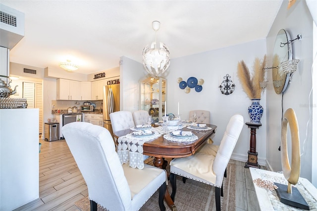 4403 S Semoran Blvd Unit 2, Orlando, FL 32822 - dining area featuring light wood-style floors and a chandelier