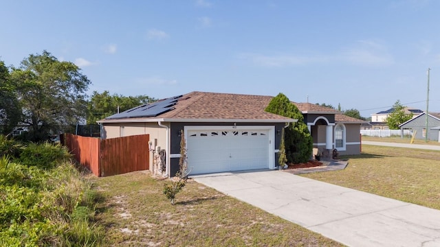 402 Ohio Way, Kissimmee, FL 34759 - view of front facade with stucco siding, driveway, an attached garage, a shingled roof, and solar panels