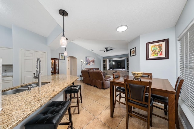 402 Ohio Way, Kissimmee, FL 34759 - dining space featuring arched walkways, a ceiling fan, vaulted ceiling, light tile patterned floors, and a textured ceiling