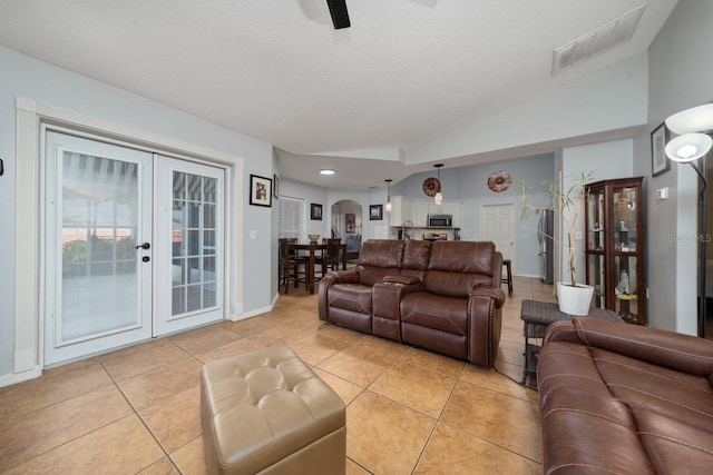 402 Ohio Way, Kissimmee, FL 34759 - living room featuring vaulted ceiling, french doors, arched walkways, light tile patterned floors, and baseboards