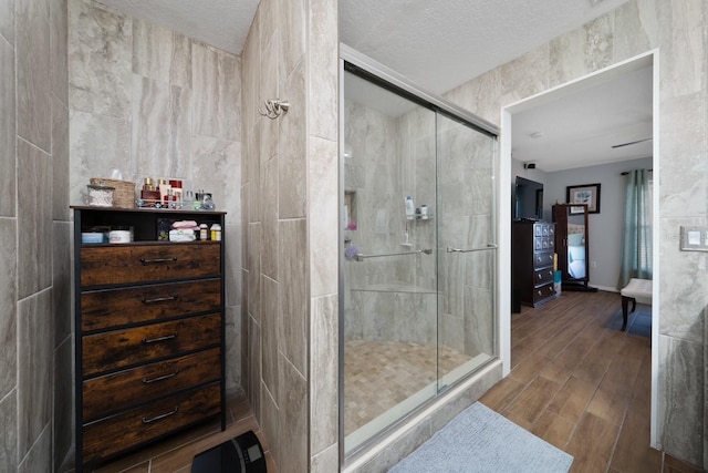 402 Ohio Way, Kissimmee, FL 34759 - full bathroom with a stall shower, wood tiled floors, tile walls, and a textured ceiling