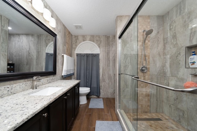 402 Ohio Way, Kissimmee, FL 34759 - bathroom with a shower stall, tile walls, vanity, wood finish floors, and toilet