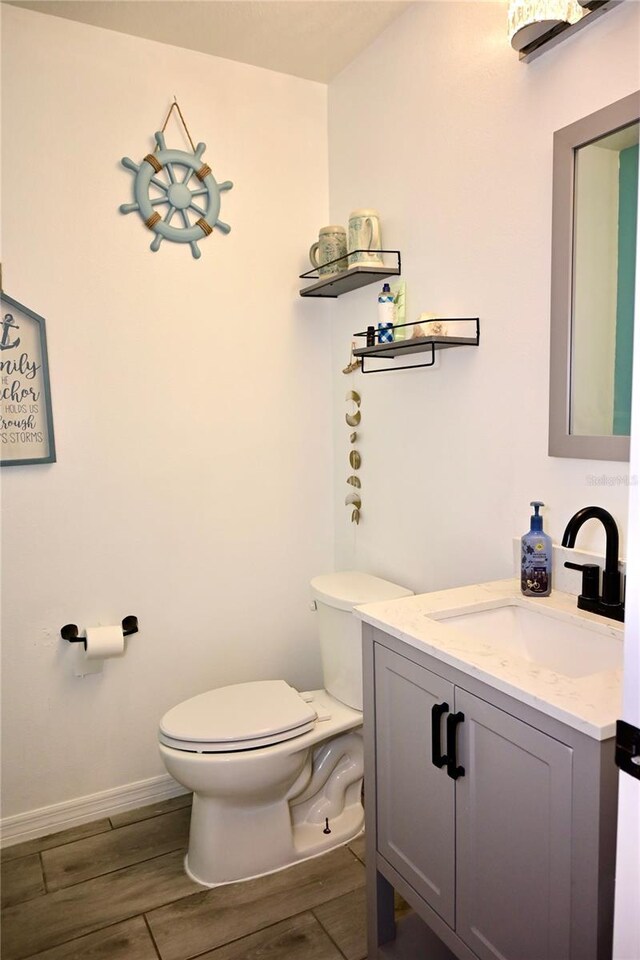 673 Sarner Pass Way, Winter Haven, FL 33881 - half bath featuring toilet, vanity, wood finished floors, and baseboards