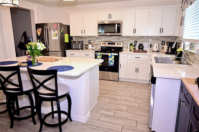 673 Sarner Pass Way, Winter Haven, FL 33881 - kitchen featuring appliances with stainless steel finishes, a sink, decorative backsplash, and white cabinets