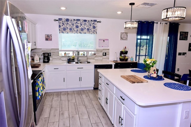 673 Sarner Pass Way, Winter Haven, FL 33881 - kitchen with stainless steel appliances, a sink, light countertops, white cabinets, and decorative backsplash