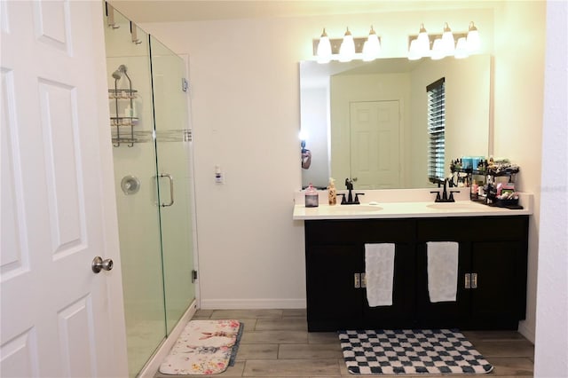 673 Sarner Pass Way, Winter Haven, FL 33881 - bathroom featuring a stall shower, wood finished floors, double vanity, and baseboards