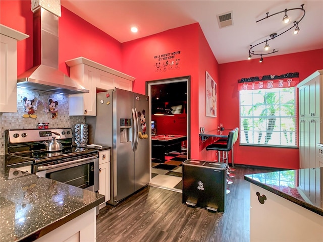 550 Canary Island Cir, Davenport, FL 33837 - kitchen with stainless steel appliances, wall chimney range hood, white cabinets, decorative backsplash, and dark wood-style floors