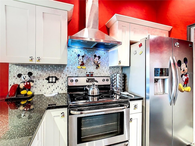 550 Canary Island Cir, Davenport, FL 33837 - kitchen featuring stainless steel appliances, wall chimney range hood, dark countertops, white cabinets, and decorative backsplash
