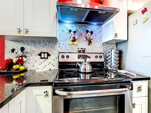 550 Canary Island Cir, Davenport, FL 33837 - kitchen with stainless steel electric stove, ventilation hood, tasteful backsplash, dark countertops, and white cabinets