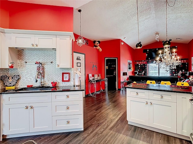 550 Canary Island Cir, Davenport, FL 33837 - kitchen with a sink, dark countertops, a textured ceiling, lofted ceiling, and decorative backsplash