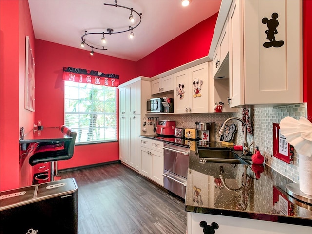 550 Canary Island Cir, Davenport, FL 33837 - kitchen with a sink, stainless steel appliances, white cabinets, dark wood-style flooring, and backsplash
