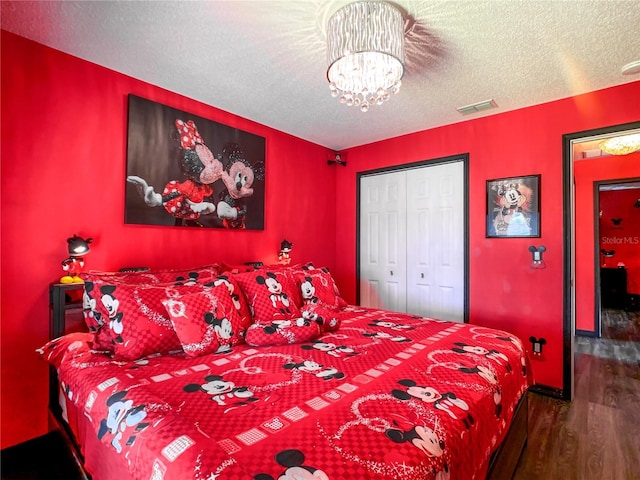 550 Canary Island Cir, Davenport, FL 33837 - bedroom with wood finished floors, a chandelier, a textured ceiling, baseboards, and a closet