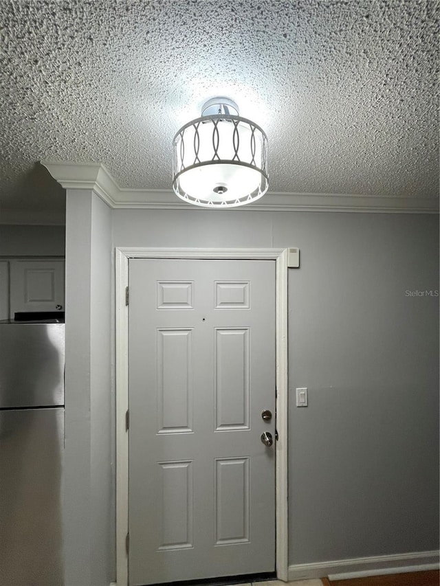 doorway with a textured ceiling and crown molding