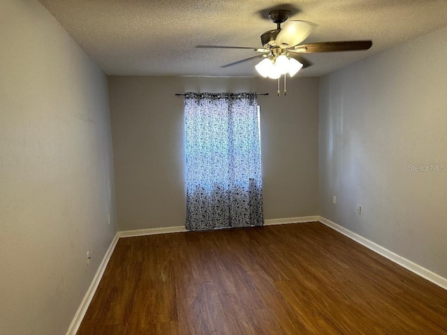 unfurnished room featuring dark wood-type flooring, a ceiling fan, baseboards, and a textured ceiling