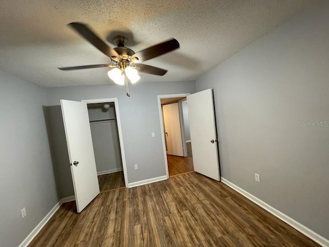 unfurnished bedroom with wood finished floors, a textured ceiling, baseboards, a closet, and a ceiling fan
