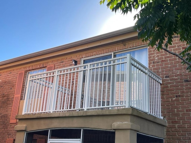 view of side of property with a balcony and brick siding