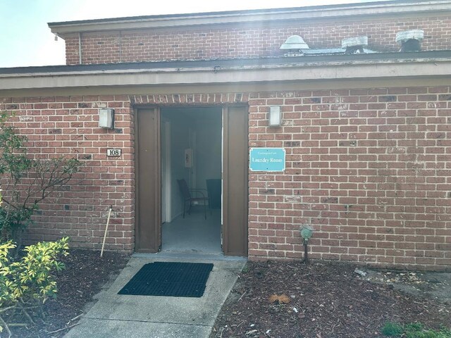 view of exterior entry featuring brick siding
