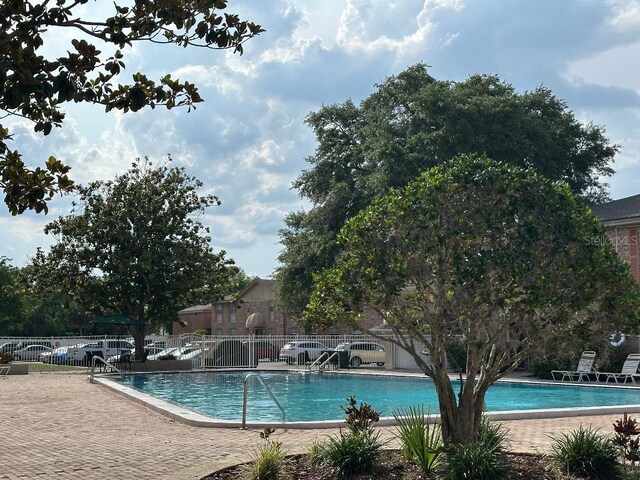 community pool featuring fence and a patio area