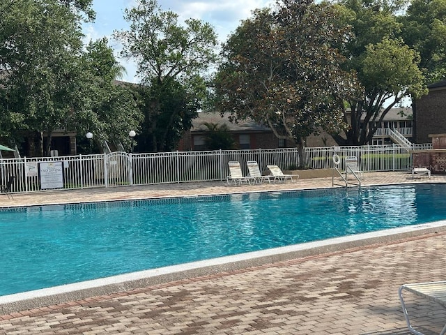 community pool featuring fence and a patio area