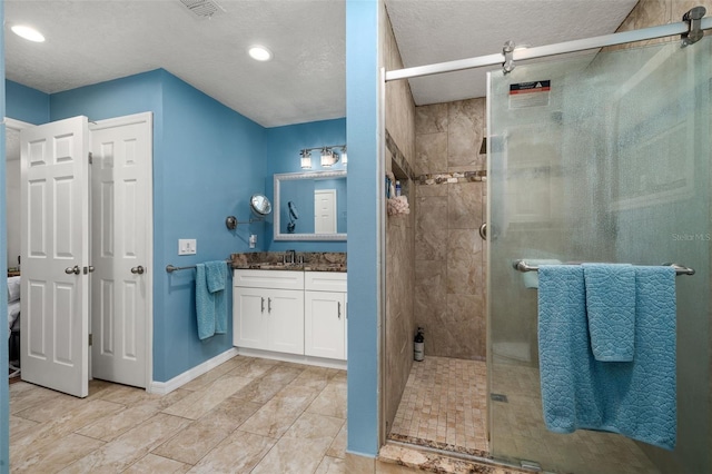 bathroom with a stall shower, vanity, recessed lighting, and baseboards