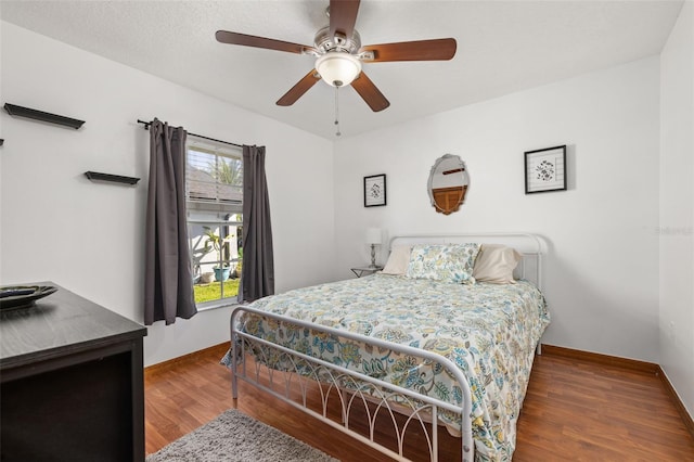 bedroom featuring wood finished floors, baseboards, and a ceiling fan