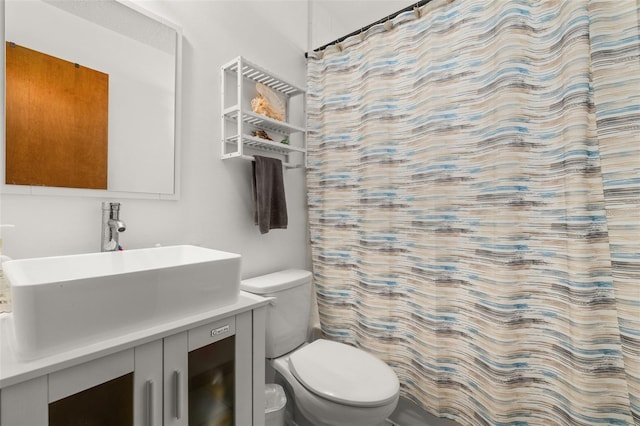 full bath with toilet, vanity, and curtained shower