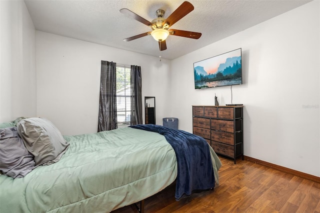 bedroom with baseboards, wood finished floors, a textured ceiling, and ceiling fan