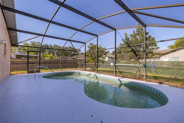 view of swimming pool with a fenced backyard, a patio area, and glass enclosure